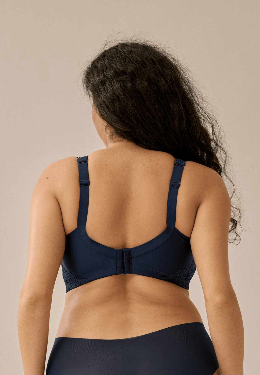 Achterzijde van vrouw die de side smoother met kant in de kleur dark blue van het merk Naturana draagt