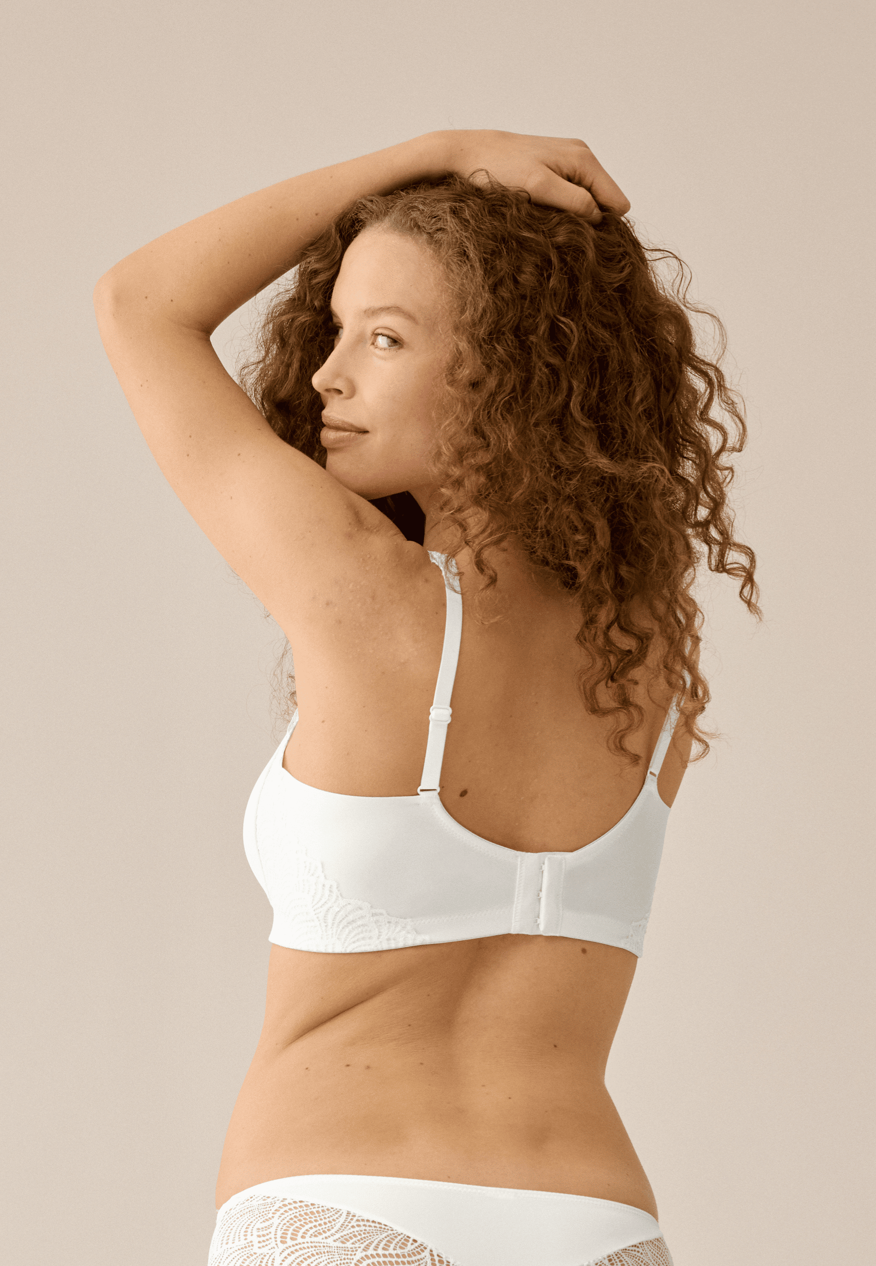 Achterzijde van vrouw die de side smoother bh met gerecycled kant in de kleur ecru van het merk Naturana draagt