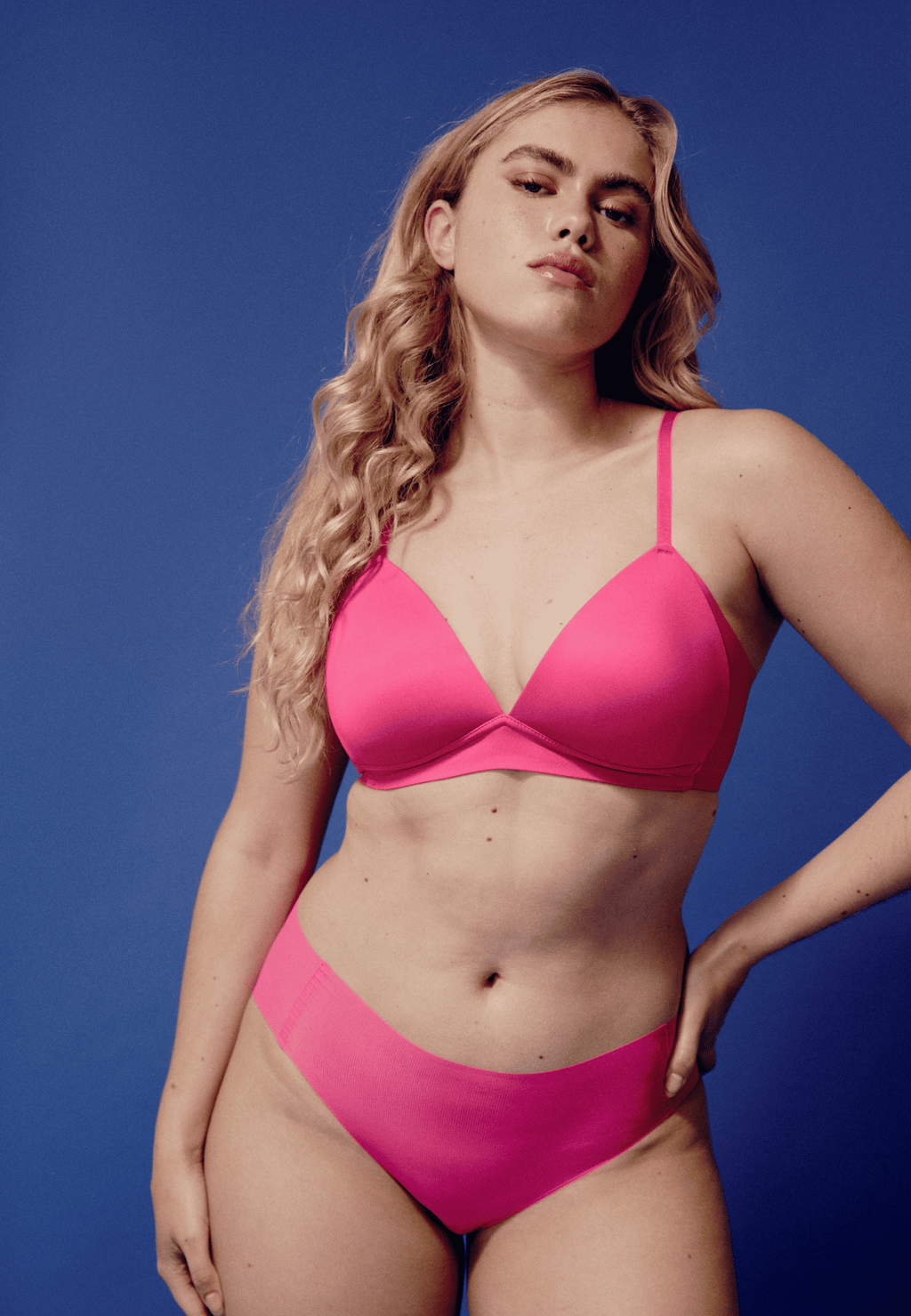 Voorzijde van vrouw die de side smoother bh en one size slip in de kleur hot pink van het merk Naturana draagt