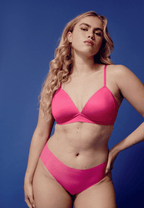 Voorzijde van vrouw die de side smoother bh en one size slip in de kleur hot pink van het merk Naturana draagt