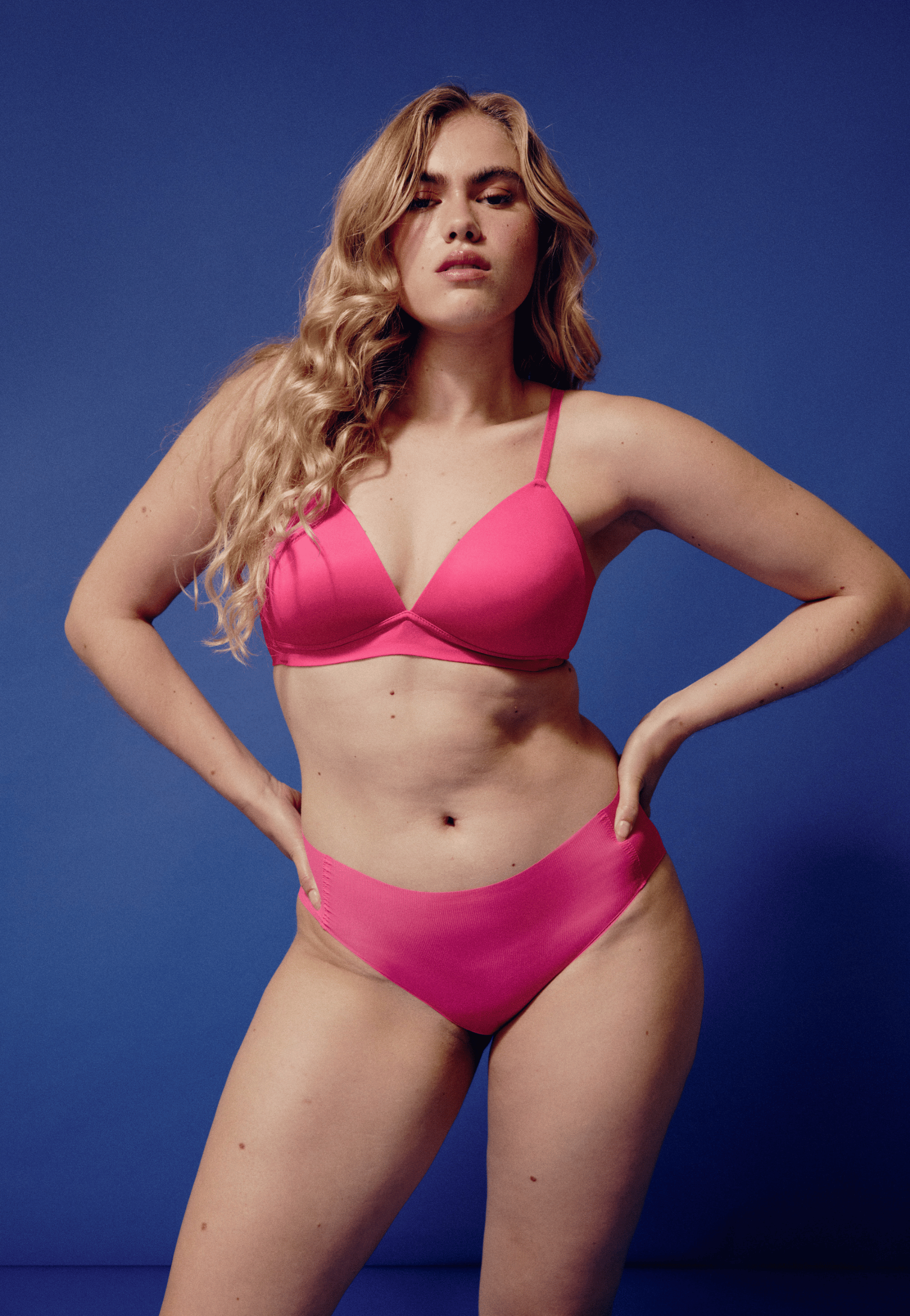 Voorzijde van vrouw die de side smoother bh en one size slip in de kleur hot pink van het merk Naturana draagt