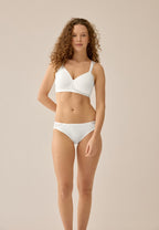 Voorzijde van vrouw die de side smoother bh en slip met gerecycled kant in de kleur ecru van het merk Naturana draagt