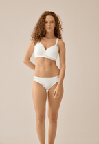 Voorzijde van vrouw die de side smoother bh met gerecycled kant en slip met met gerecycled kant in de kleur ecru van het merk Naturana draagt