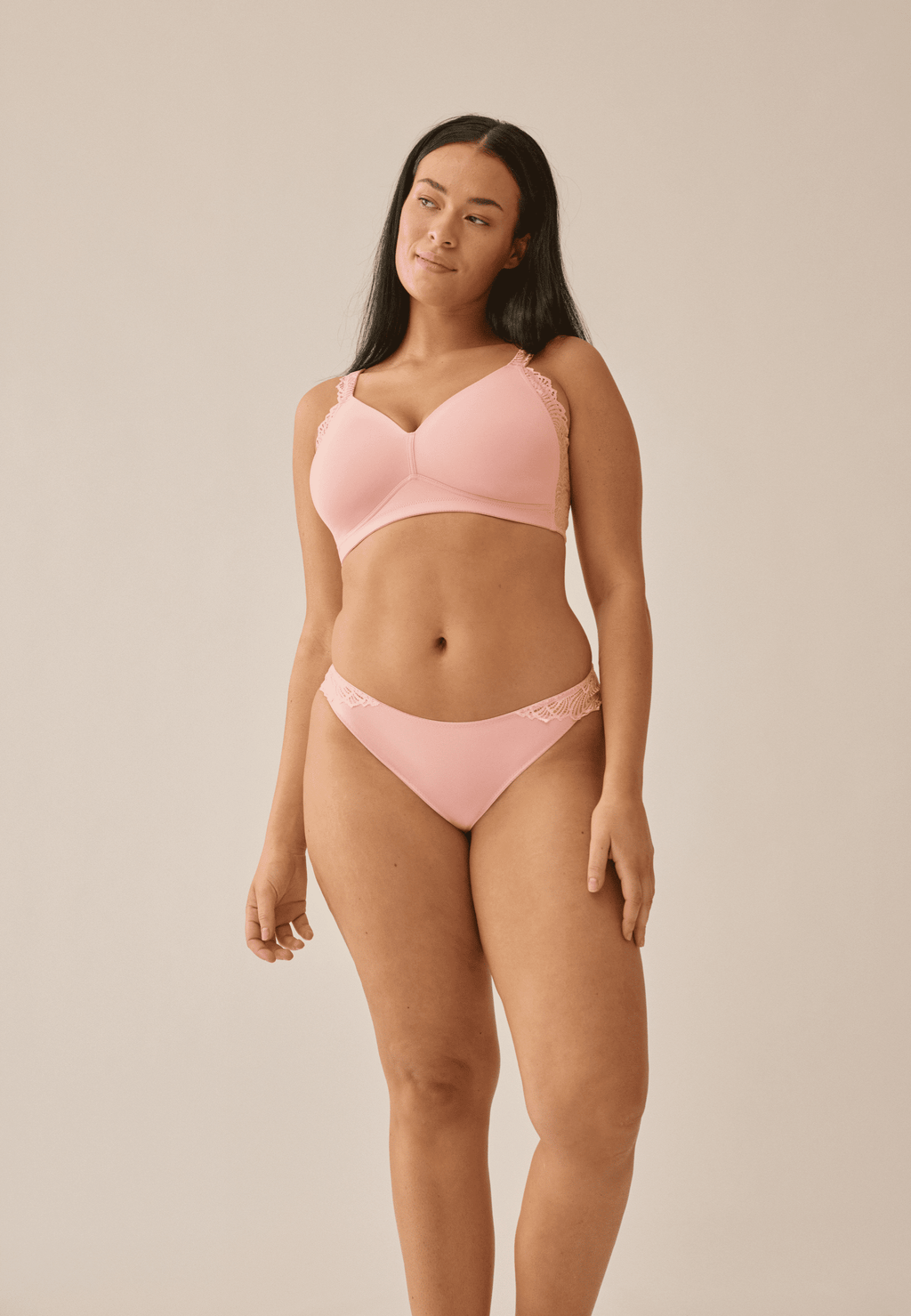 Voorzijde van vrouw die de side smoother bh met gerecycled kant en slip met gerecycled kant in de kleur pink rose van het merk Naturana draagt