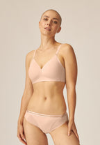 Voorzijde van vrouw die de side smoother bh en slip met mesh detail in de kleur beige van het merk Naturana draagt