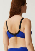 Achterzijde van vrouw die de minimizer bh met side smoother in de kleur indigo van het merk Naturana draagt