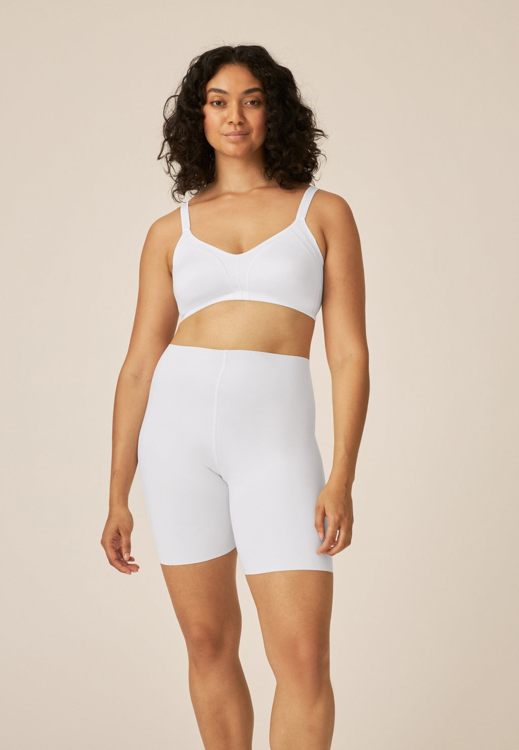 Voorzijde van vrouw die de minimizer bh met side smoother in de kleur wit van het merk Naturana draagt