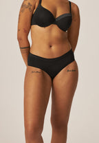 Voorzijde van vrouw die de slip met glansband in de kleur zwart van het merk Naturana draagt