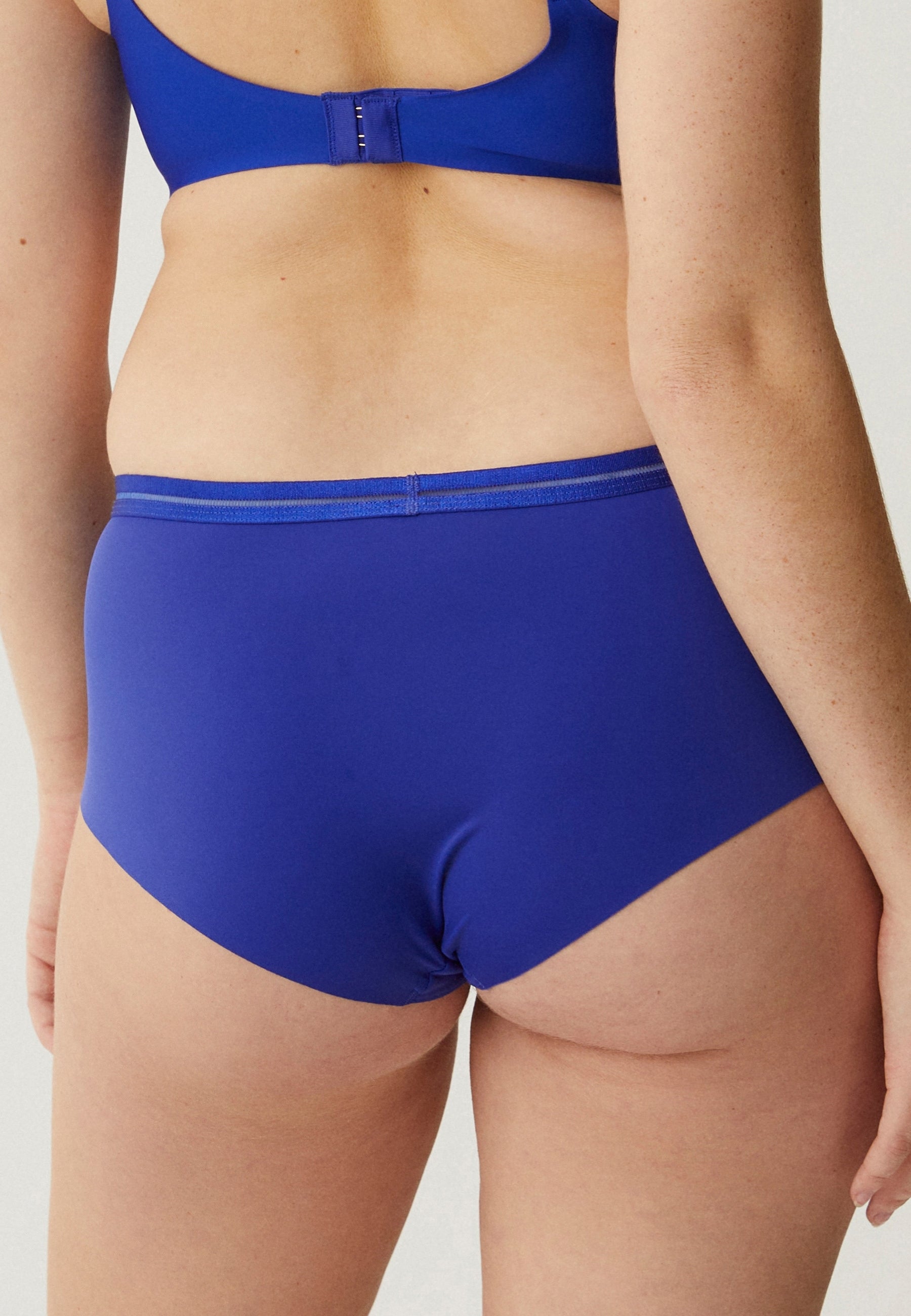 Achterzijde van vrouw die de slip met mesh detail in de kleur indigo van het merk Naturana draagt