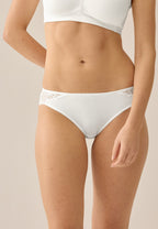 Voorzijde van vrouw die de slip met gerecycled kant in de kleur ecru van het merk Naturana draagt