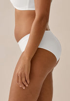 Zijde van vrouw die de slip met glansband in de kleur ecru van het merk Naturana draagt