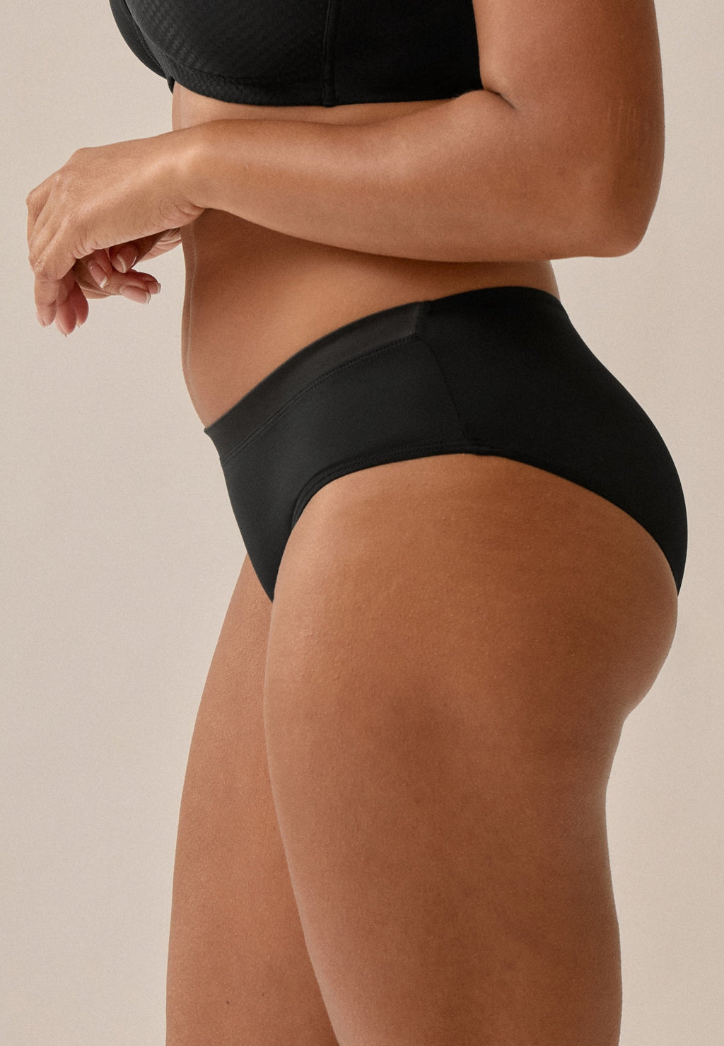 Zijde van vrouw die de slip met glansband in de kleur zwart van het merk Naturana draagt