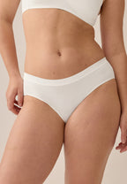 Voorzijde van vrouw die de slip met glansband in de kleur ecru van het merk Naturana draagt