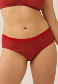 Voorzijde van vrouw die de slip met glansband in de kleur negroni print van het merk Naturana draagt