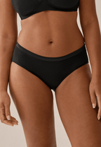 Voorzijde van vrouw die de slip met glansband in de kleur zwart van het merk Naturana draagt