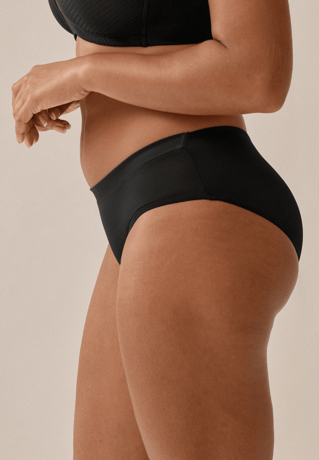 Zijde van vrouw die de slip met glansband in de kleur zwart van het merk Naturana draagt