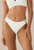 Voorzijde van vrouw die de slip met gerecycled kant in de kleur ecru van het merk Naturana draagt