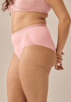 Zijde van vrouw die de slip met mesh detail in de kleur pink rose van het merk Naturana draagt