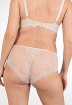 Achterzijde van vrouw die de slip met kant in de kleur beige van het merk Naturana draagt