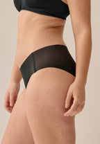 Zijde van vrouw die de slip one size in de kleur zwart van het merk Naturana draagt