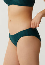 Zijde van vrouw die de slip met strepen in de kleur groen van het merk Naturana draagt