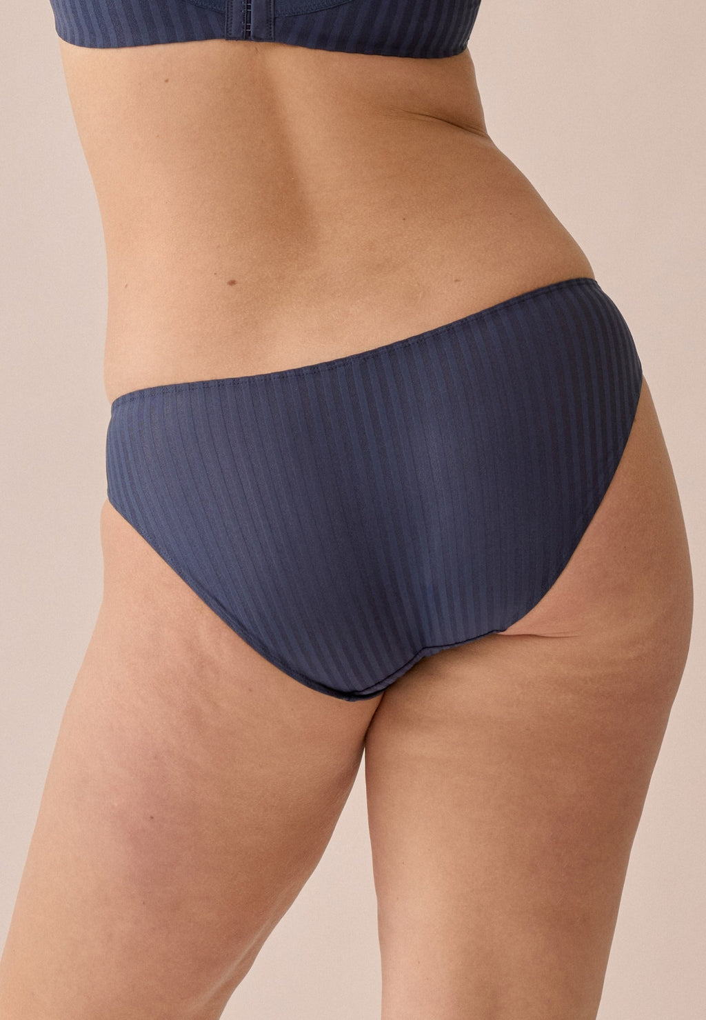 Achterzijde van vrouw die de slip met strepen in de kleur navy van het merk Naturana draagt