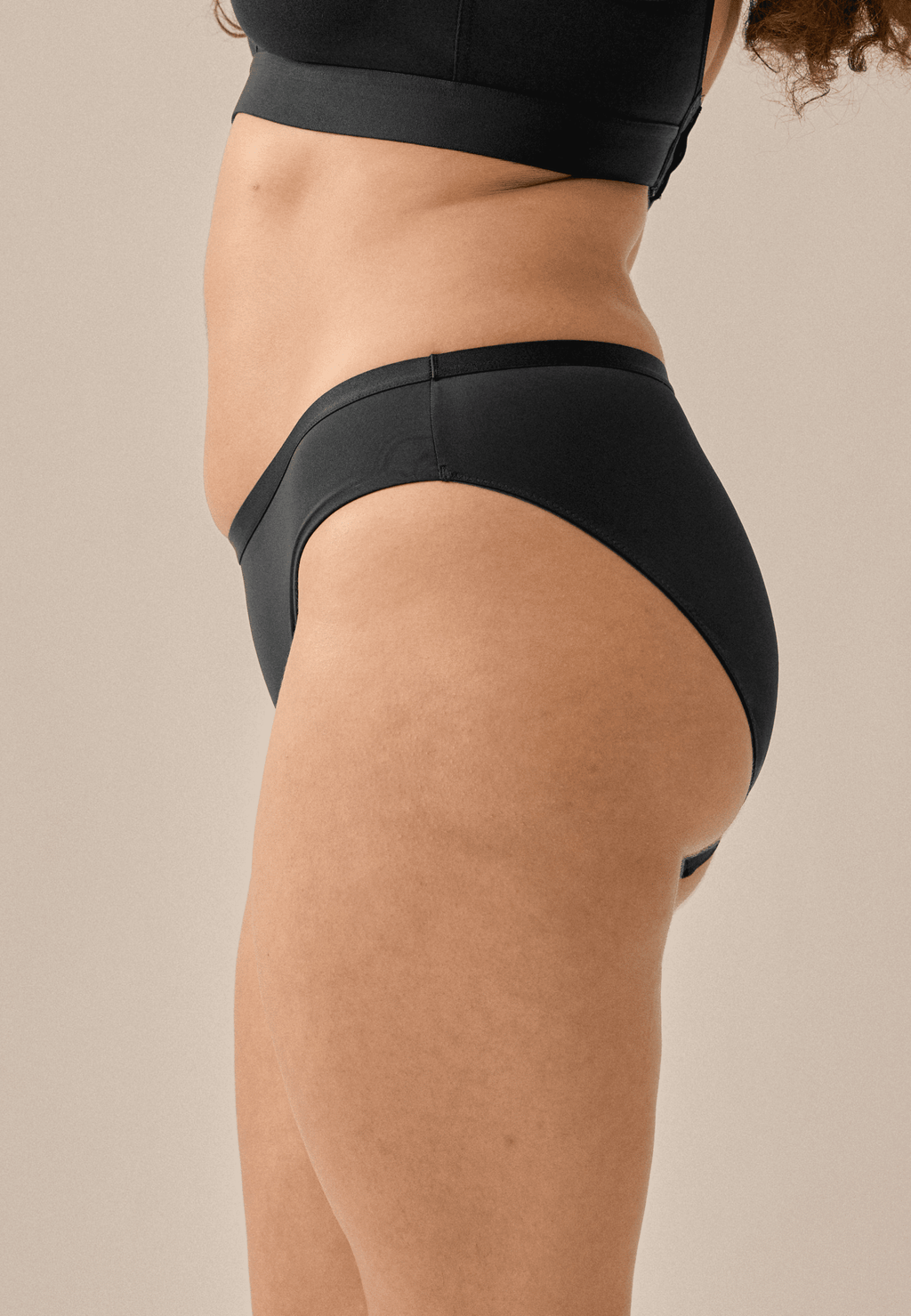 Zijde van vrouw die de slip in de kleur zwart van het merk Naturana draagt