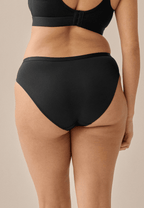 Achterzijde van vrouw die de slip in de kleur zwart van het merk Naturana draagt