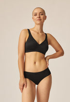 Voorzijde van vrouw die de slip met glansband in de kleur zwart van het merk Naturana draagt