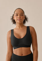 Voorzijde van vrouw die de smoothing bh in de kleur zwart van het merk Naturana draagt