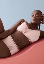 Voorzijde van vrouw die de soft bh met mesh detail en slip met mesh detail in de kleur pink rose van het merk Naturana draagt