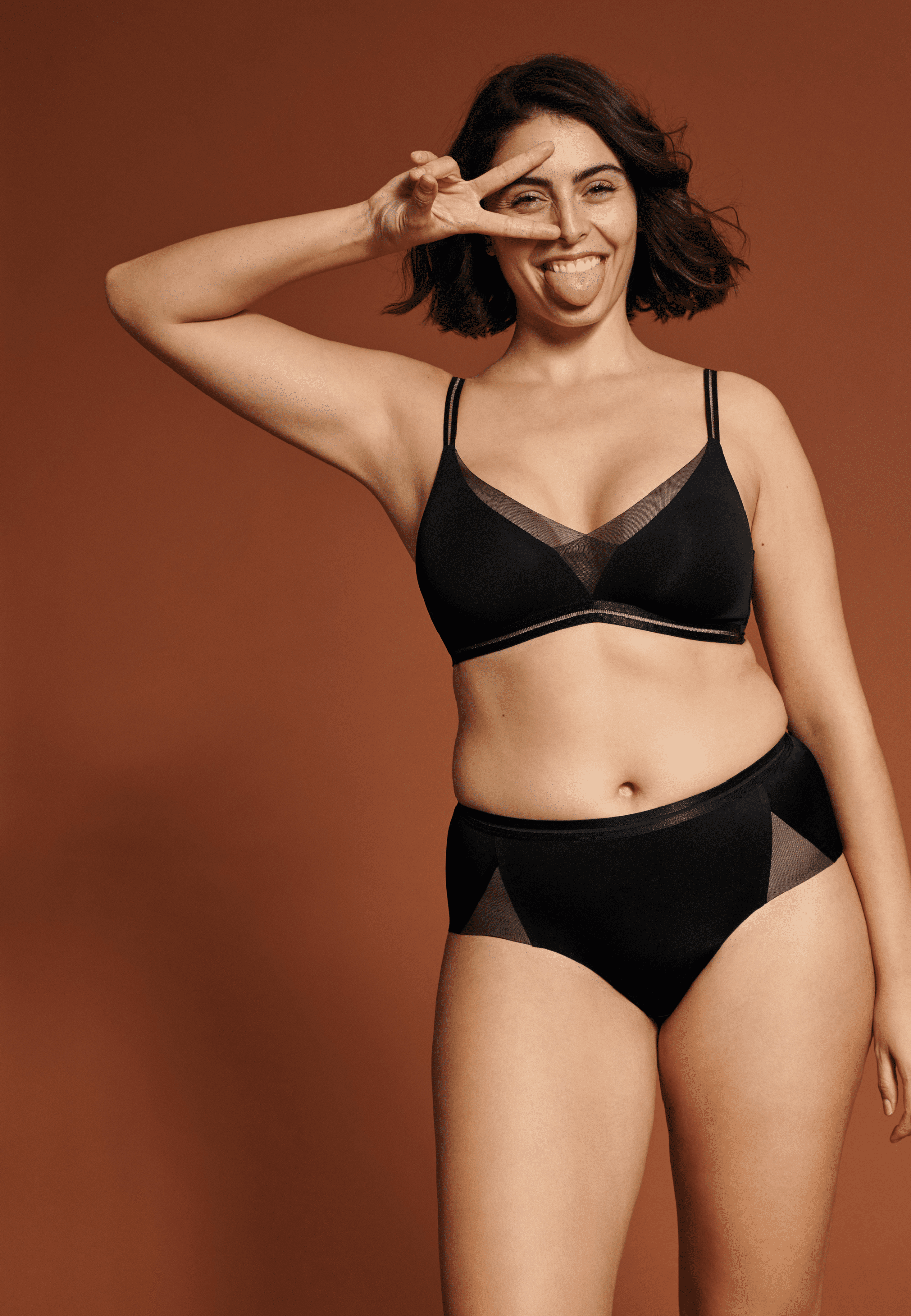 Voorzijde van vrouw die de soft bh met mesh detail en slip met mesh detail in de kleur zwart van het merk Naturana draagt