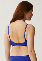 Achterzijde van vrouw die de soft bh met mesh detail in de kleur indigo van het merk Naturana draagt