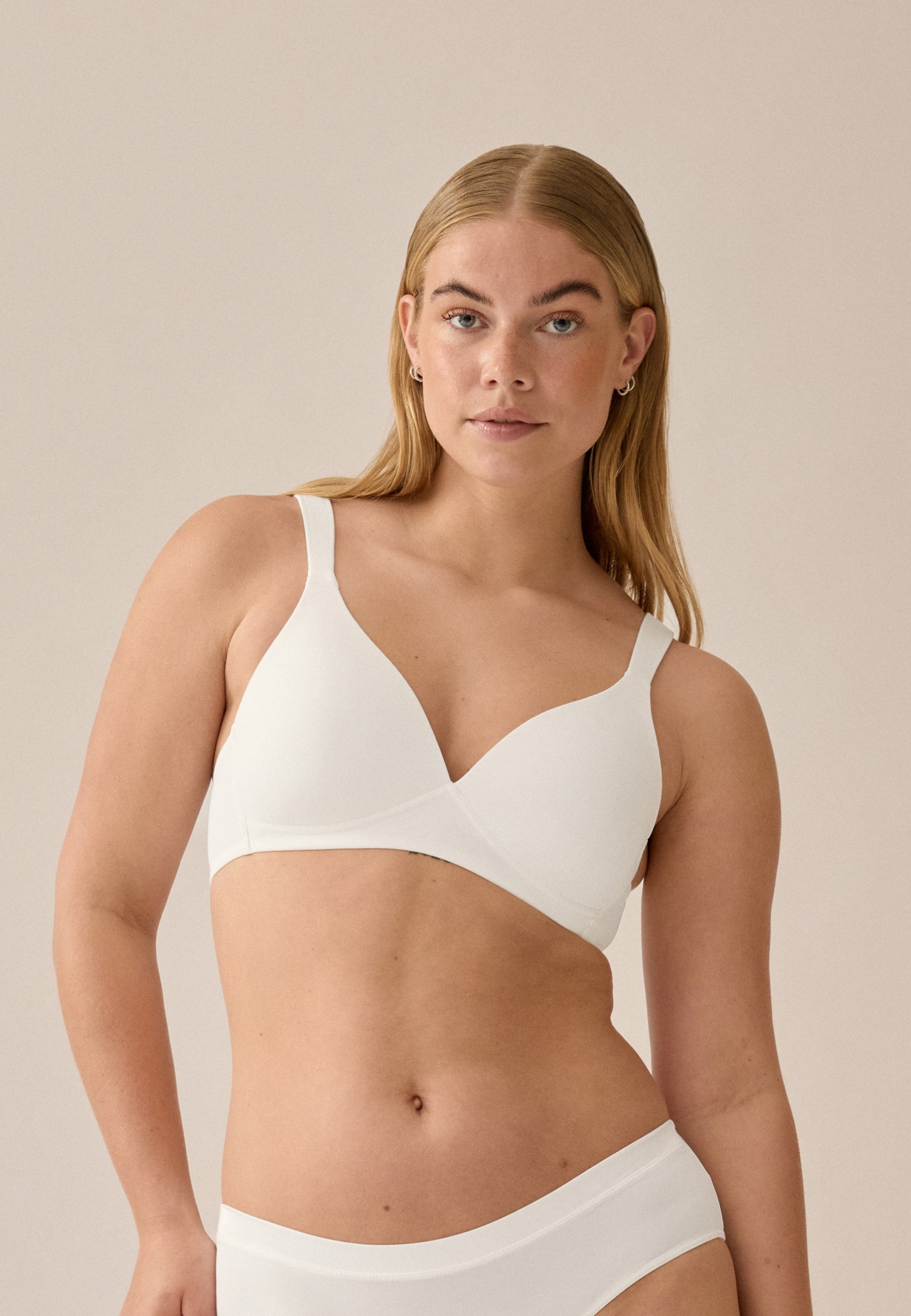 Voorzijde van vrouw die de soft bh met brede bandjes in de kleur ecru van het merk Naturana draagt