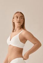 Zijde van vrouw die de soft bh met brede bandjes in de kleur ecru van het merk Naturana draagt