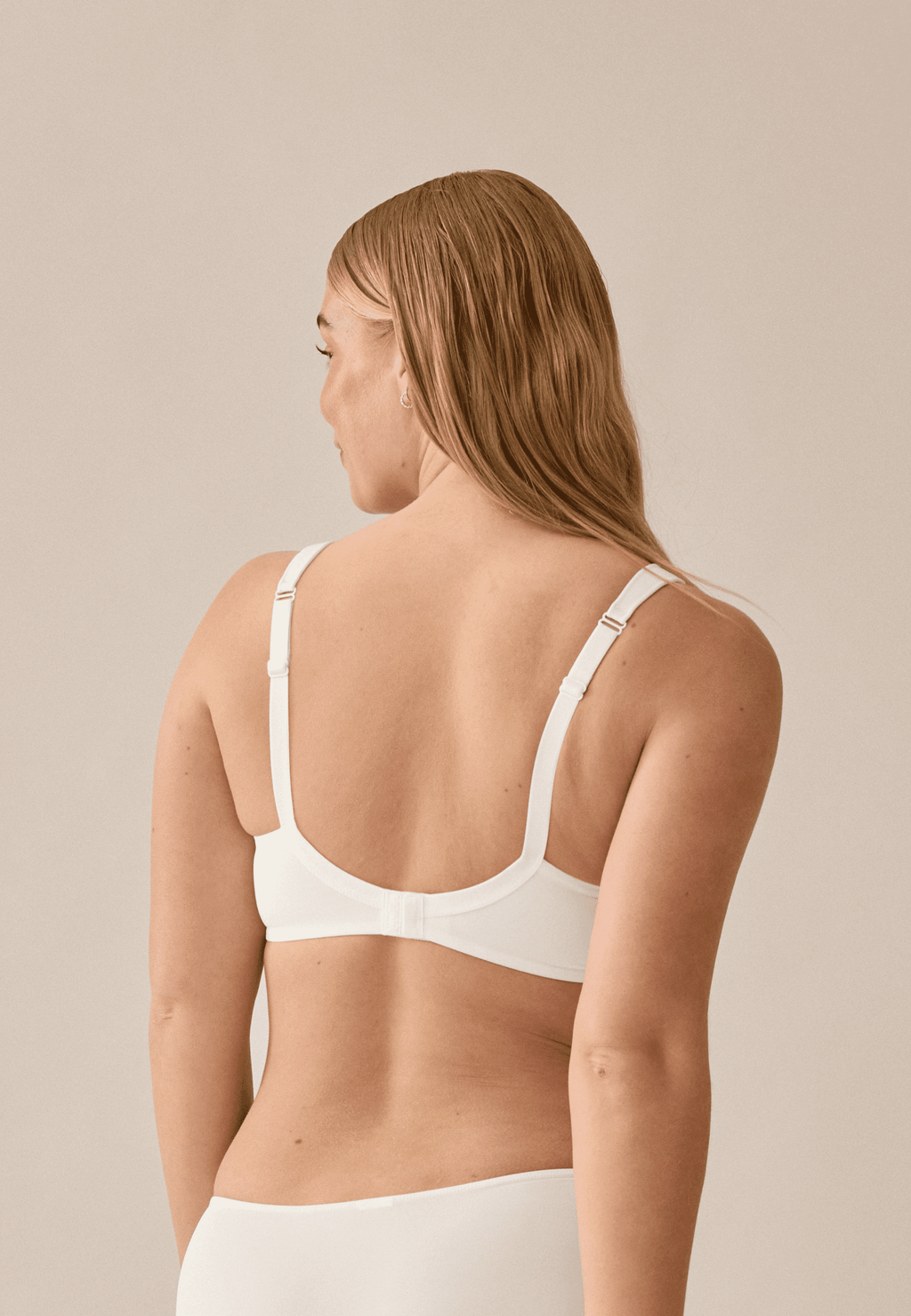 Achterzijde van vrouw die de soft bh met brede bandjes in de kleur ecru van het merk Naturana draagt