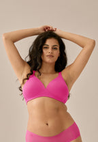 Voorzijde van vrouw die de soft bh met brede bandjes in de kleur hot pink van het merk Naturana draagt