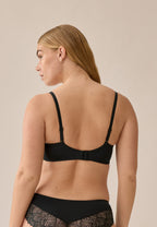 Achterzijde van vrouw die de voorgevormde soft bh met gerecycled kant in de kleur zwart van het merk Naturana draagt