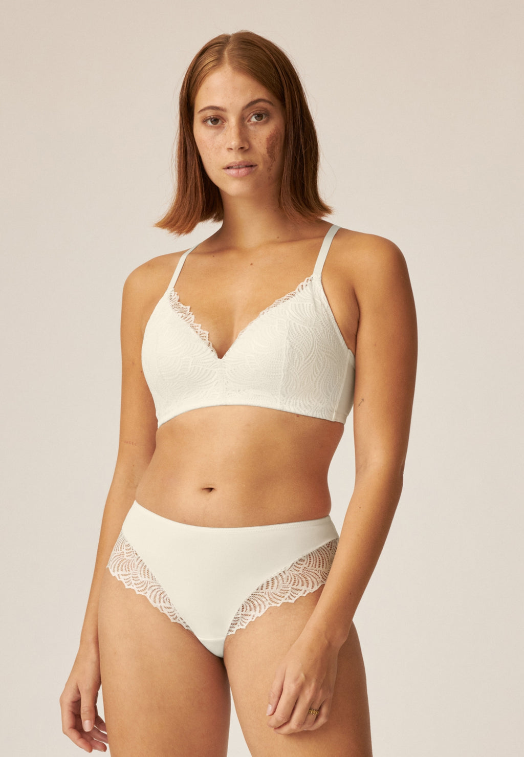 Voorzijde van vrouw die de de soft bh  met gerecycled kant en hipster met gerecycled kant in de kleur ecru van het merk Naturana draagt
