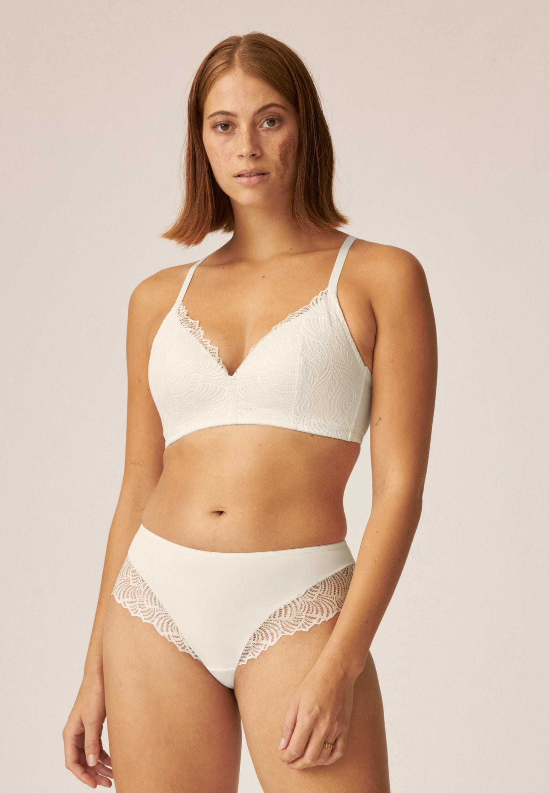 Voorzijde van vrouw die de de soft bh  met gerecycled kant en hipster met gerecycled kant in de kleur ecru van het merk Naturana draagt
