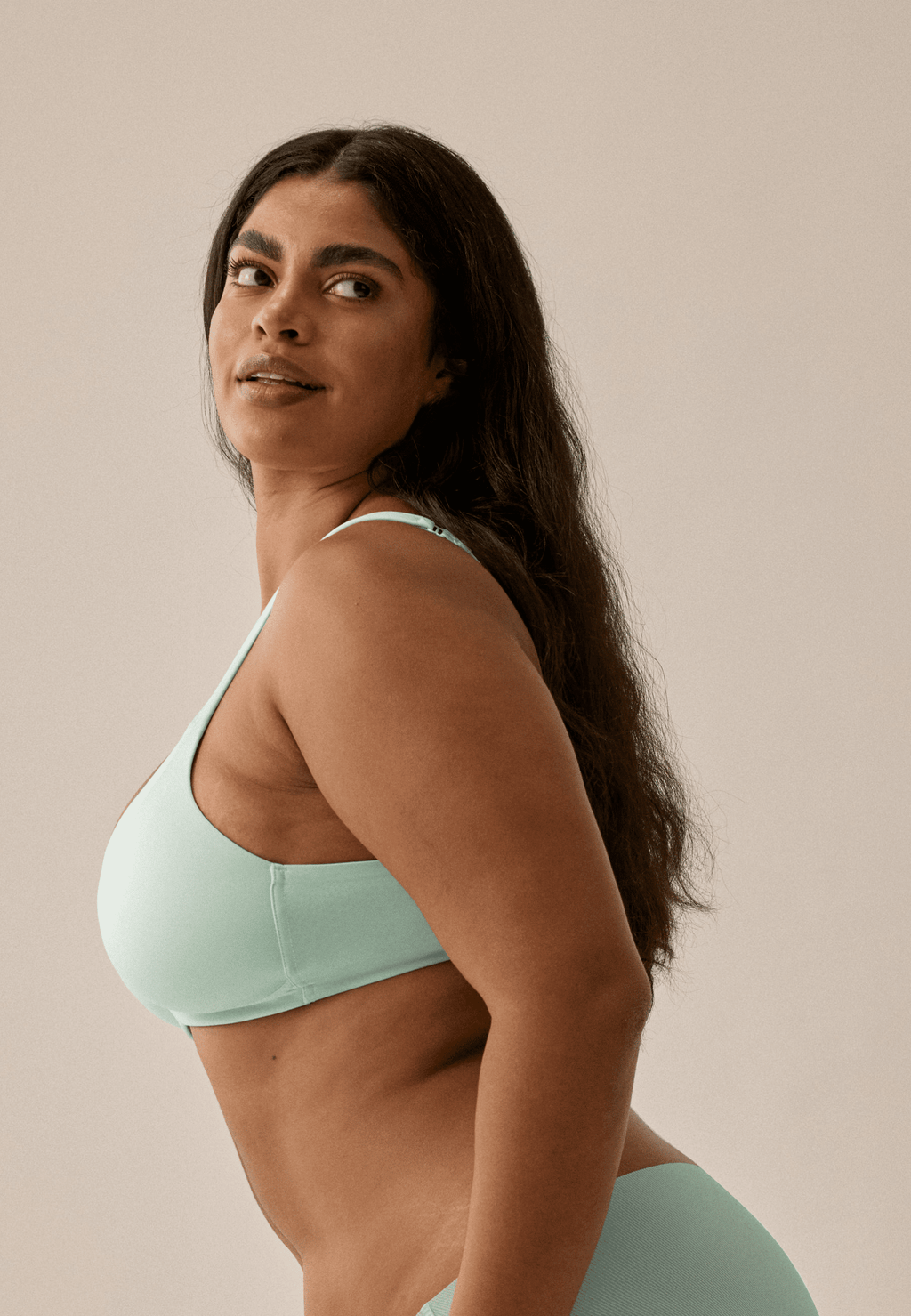 Zijde van vrouw die de soft bh met glansband in de kleur aquamenta van het merk Naturana draagt