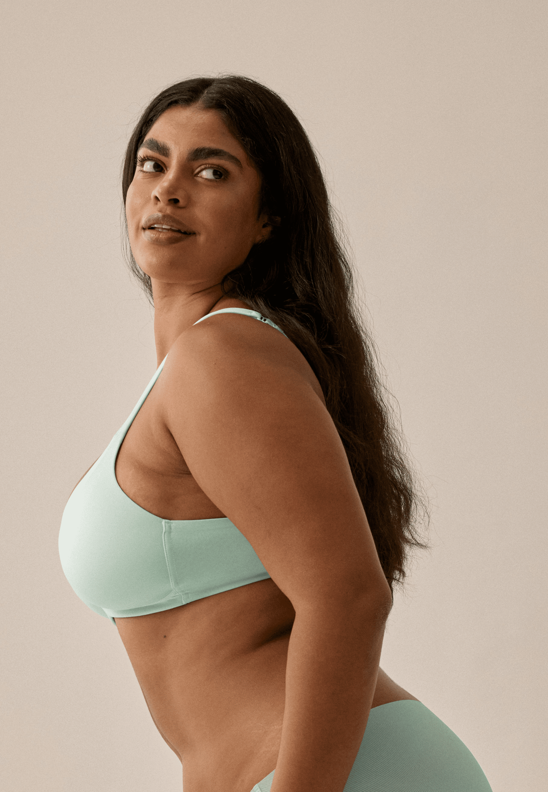 Zijde van vrouw die de soft bh met glansband in de kleur aquamenta van het merk Naturana draagt