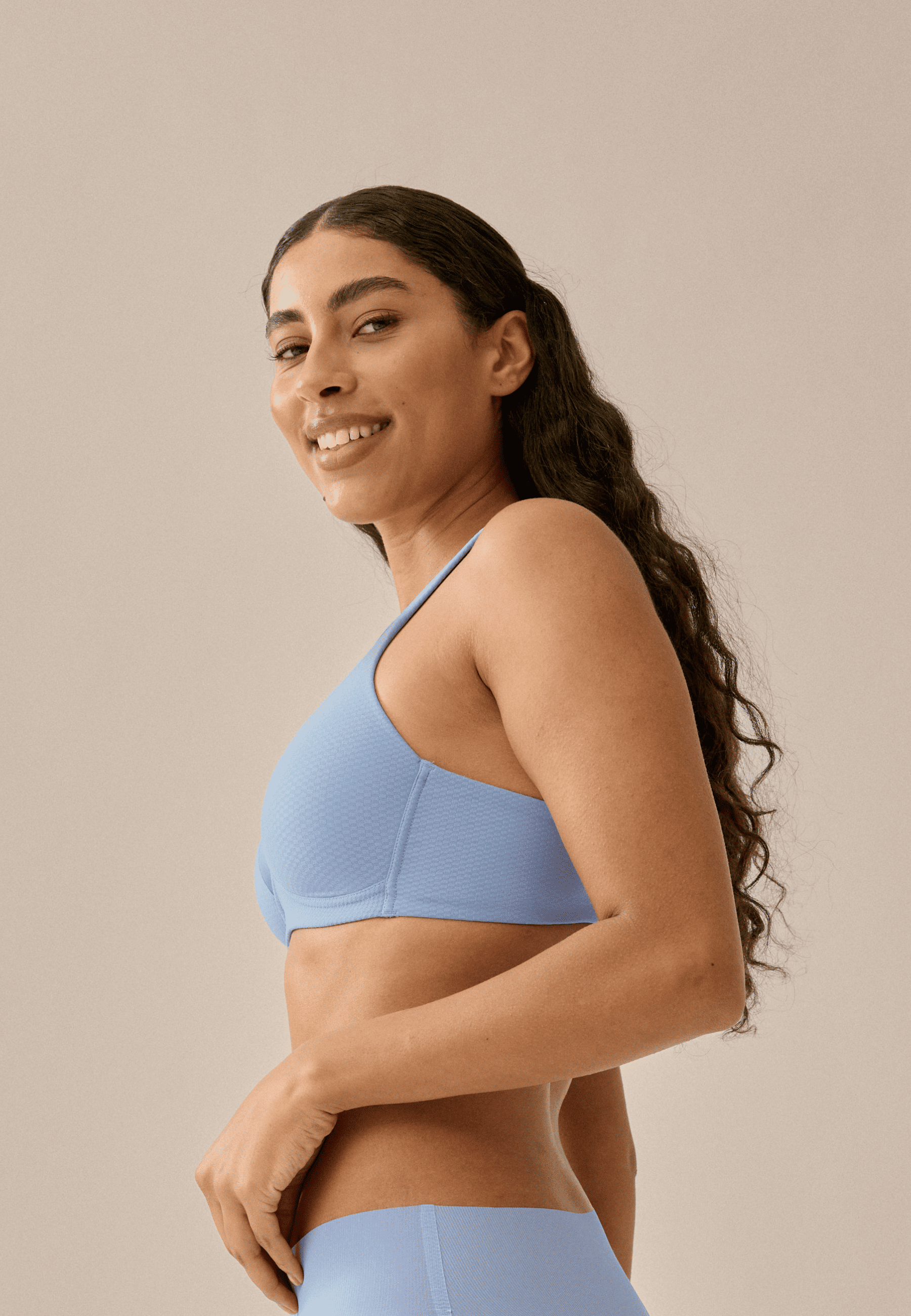 Zijde van vrouw die de soft bh met glansband en patroon in de kleur forever blue van het merk Naturana draagt