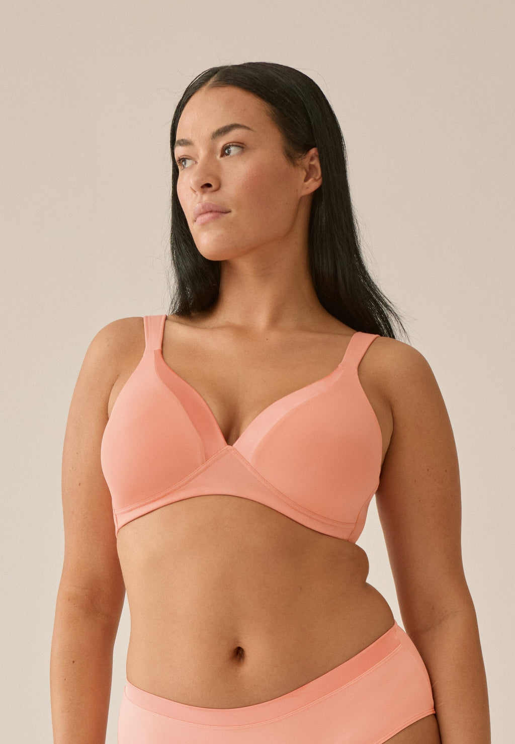 Voorzijde van vrouw die de soft bh met glansband in de kleur peach pink van het merk Naturana draagt