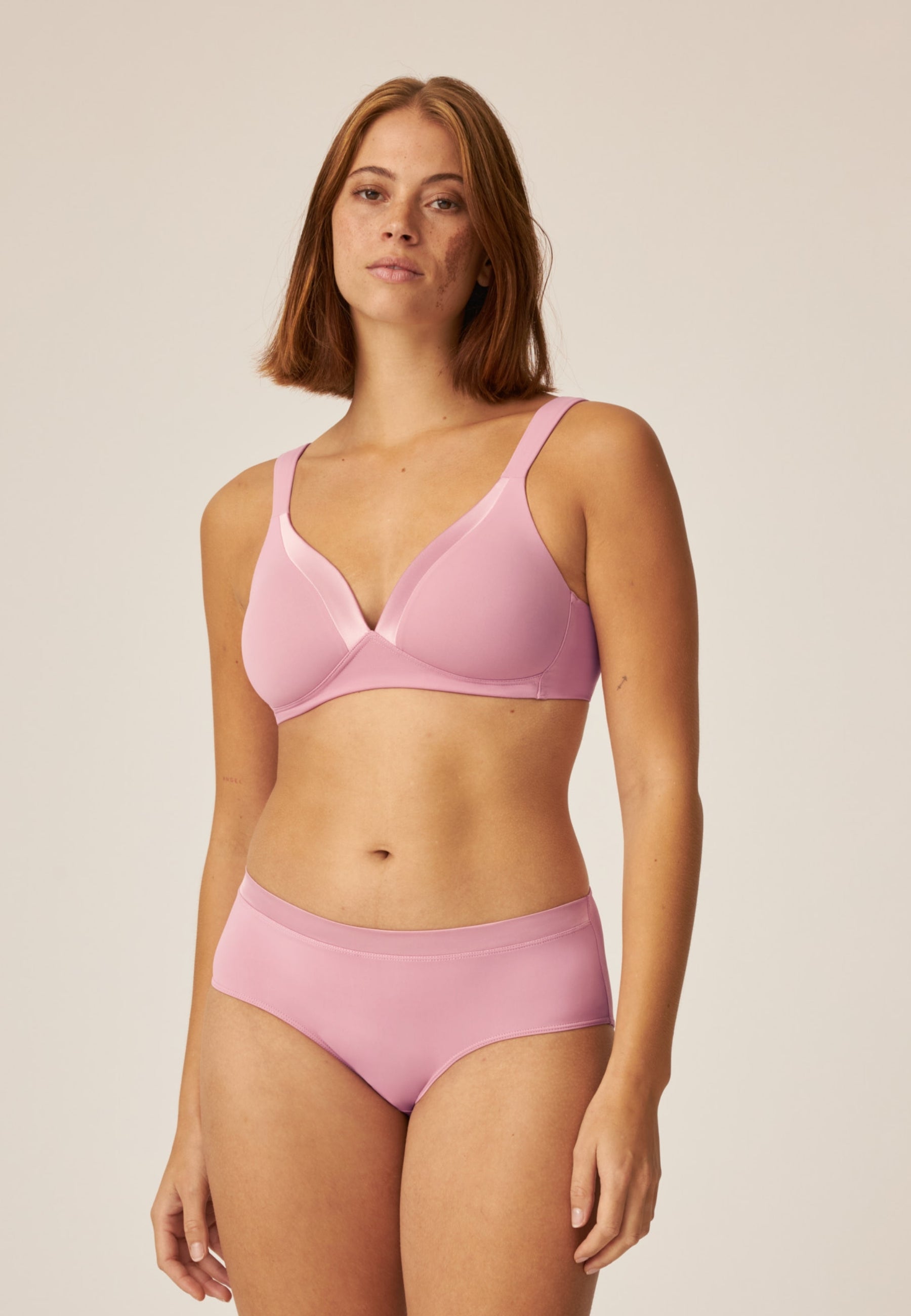 Voorzijde van vrouw die de soft bh en slip met glansband in de kleur smoked orchid van het merk Naturana draagt