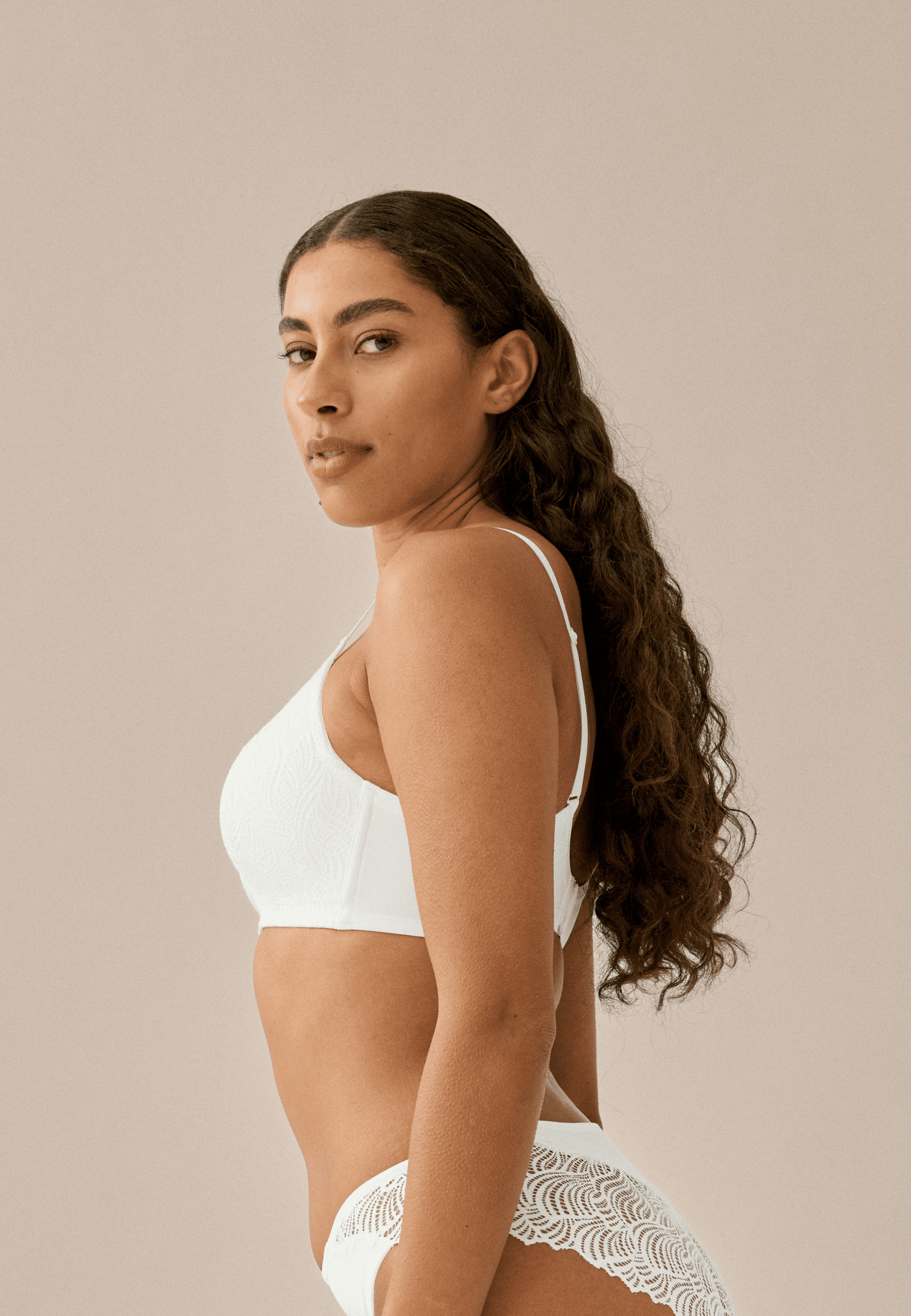 Zijde van vrouw die de soft bh met gerecycled kant in de kleur ecru van het merk Naturana draagt