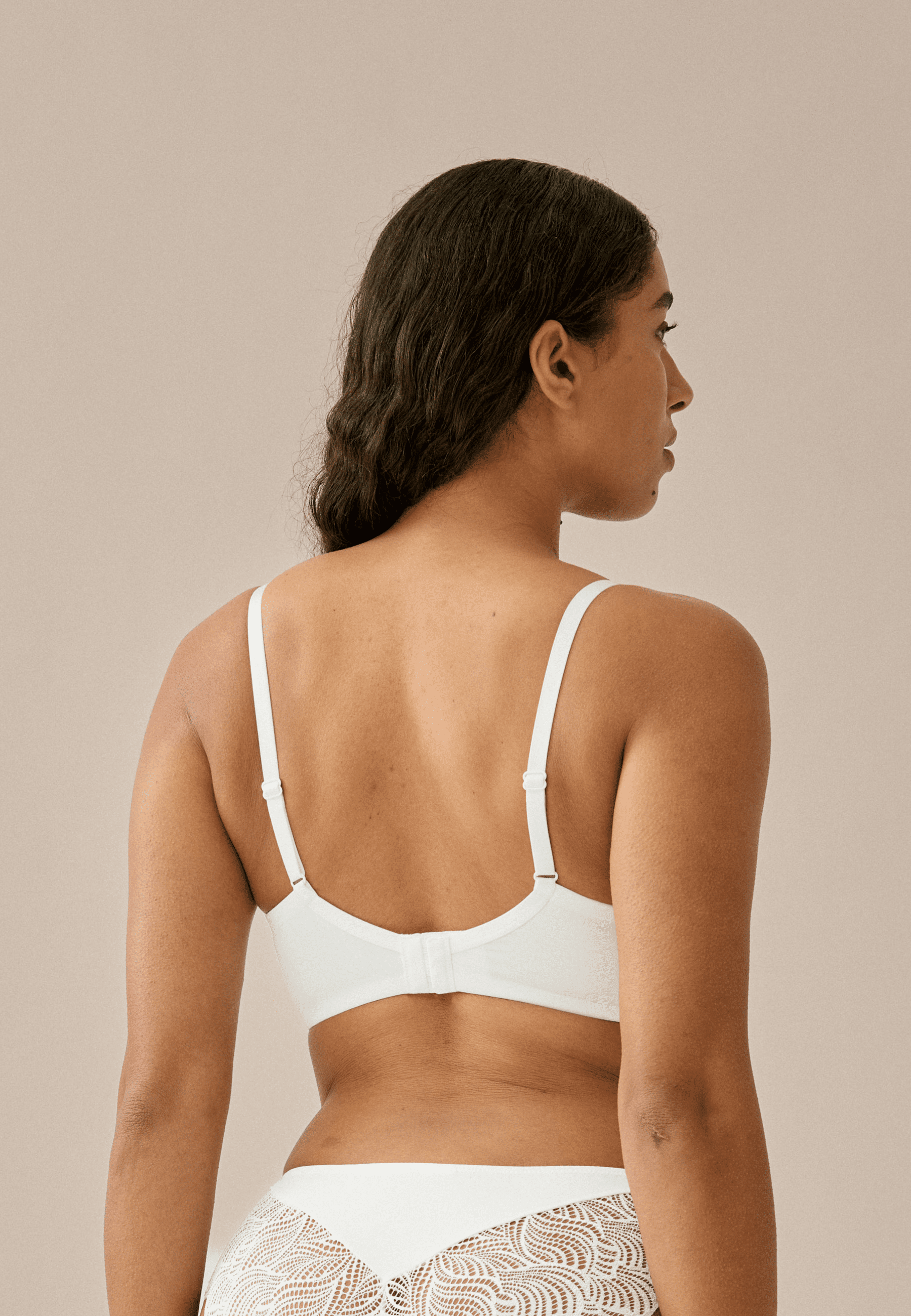 Achterzijde van vrouw die de soft bh met gerecycled kant in de kleur ecru van het merk Naturana draagt