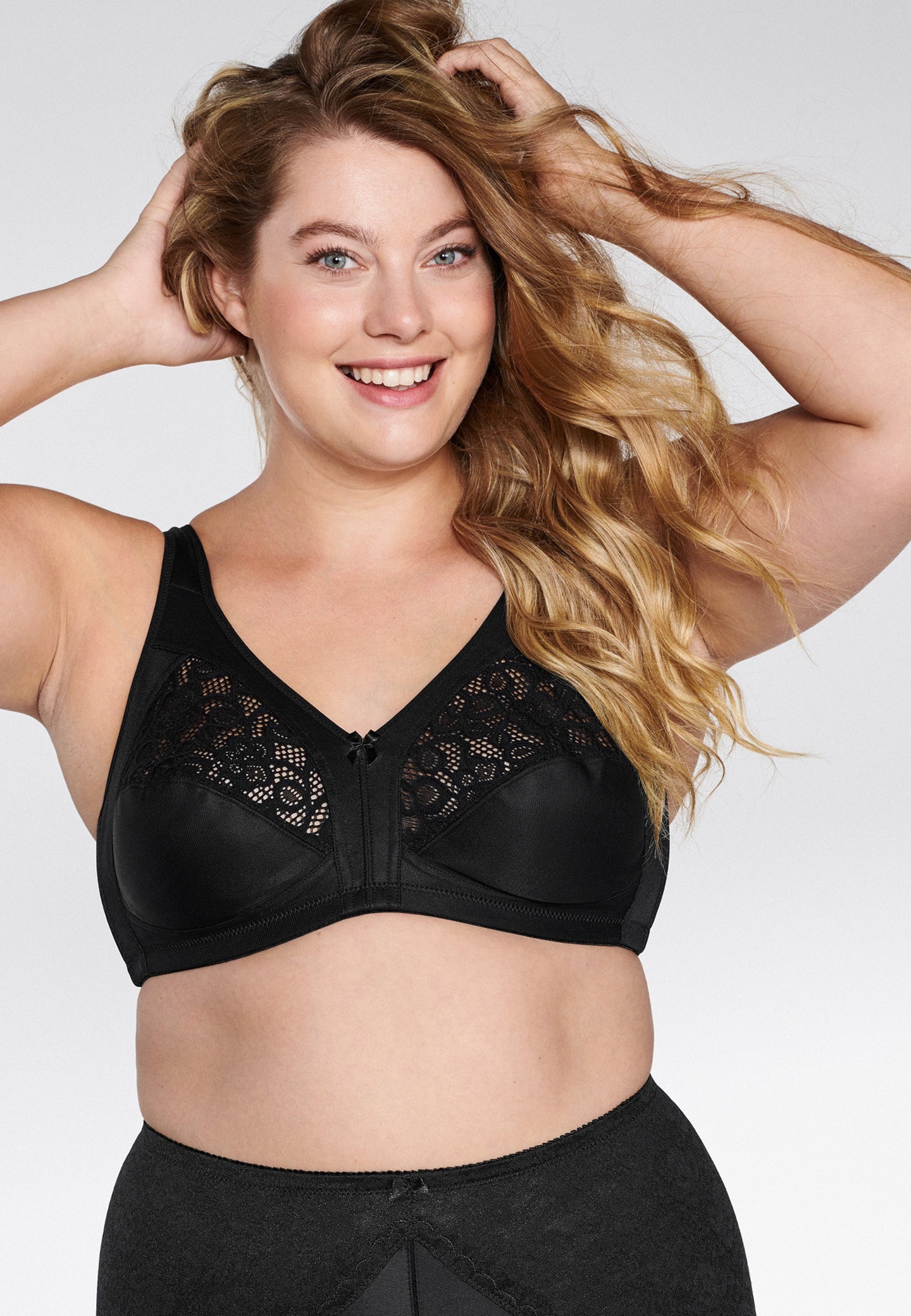 Voorzijde van vrouw die de soft bh met kanten detail in de kleur zwart van het merk Naturana draagt