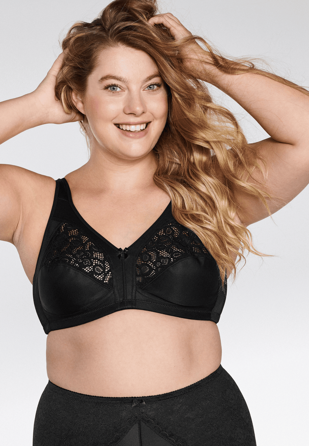Voorzijde van vrouw die de soft bh met kanten detail in de kleur zwart van het merk Naturana draagt