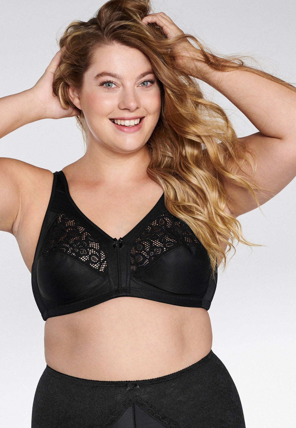 Voorzijde van vrouw die de soft bh met kanten detail in de kleur zwart van het merk Naturana draagt